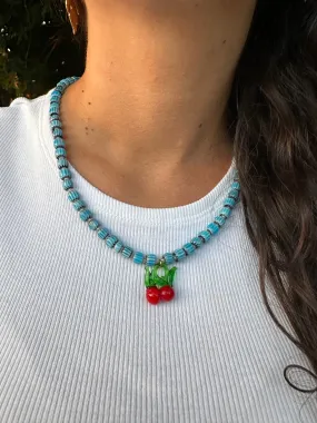 Collar con cerámica azul clarito, bolitas blancas y cerezas de cristal